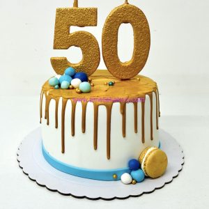 Pastel drip cake dorado con números de chocolate